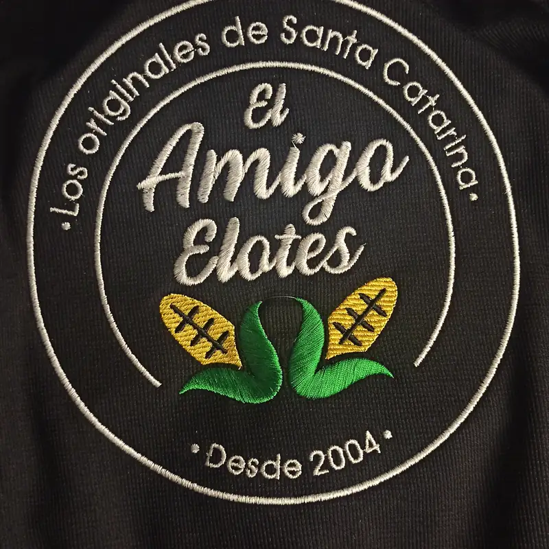 Logotipo circular bordado en blanco y verde sobre tela negra